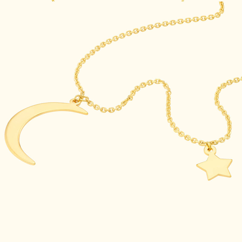 Gold necklace featuring a crescent moon and star pendant on a delicate chain.