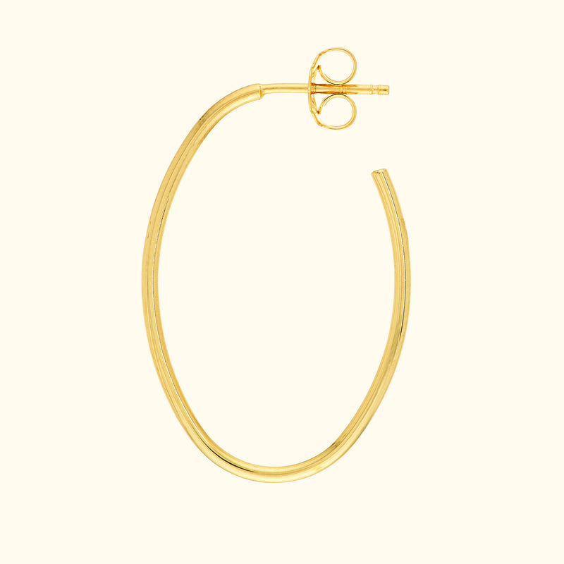 Gold hoop earring with a simple, elegant design against a light background.