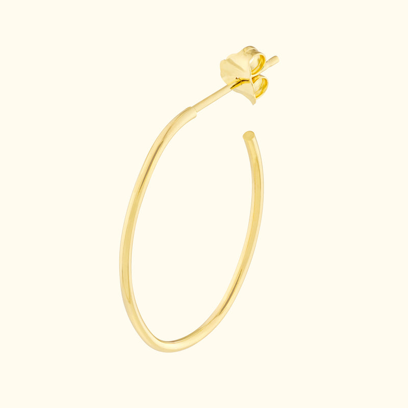 Gold hoop earring with a delicate floral design at the top.