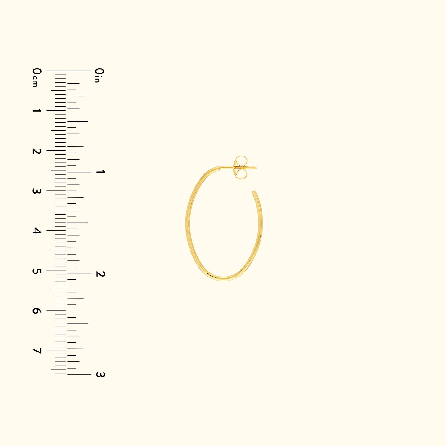Gold hoop earring with a secure clasp, next to a ruler for size reference.