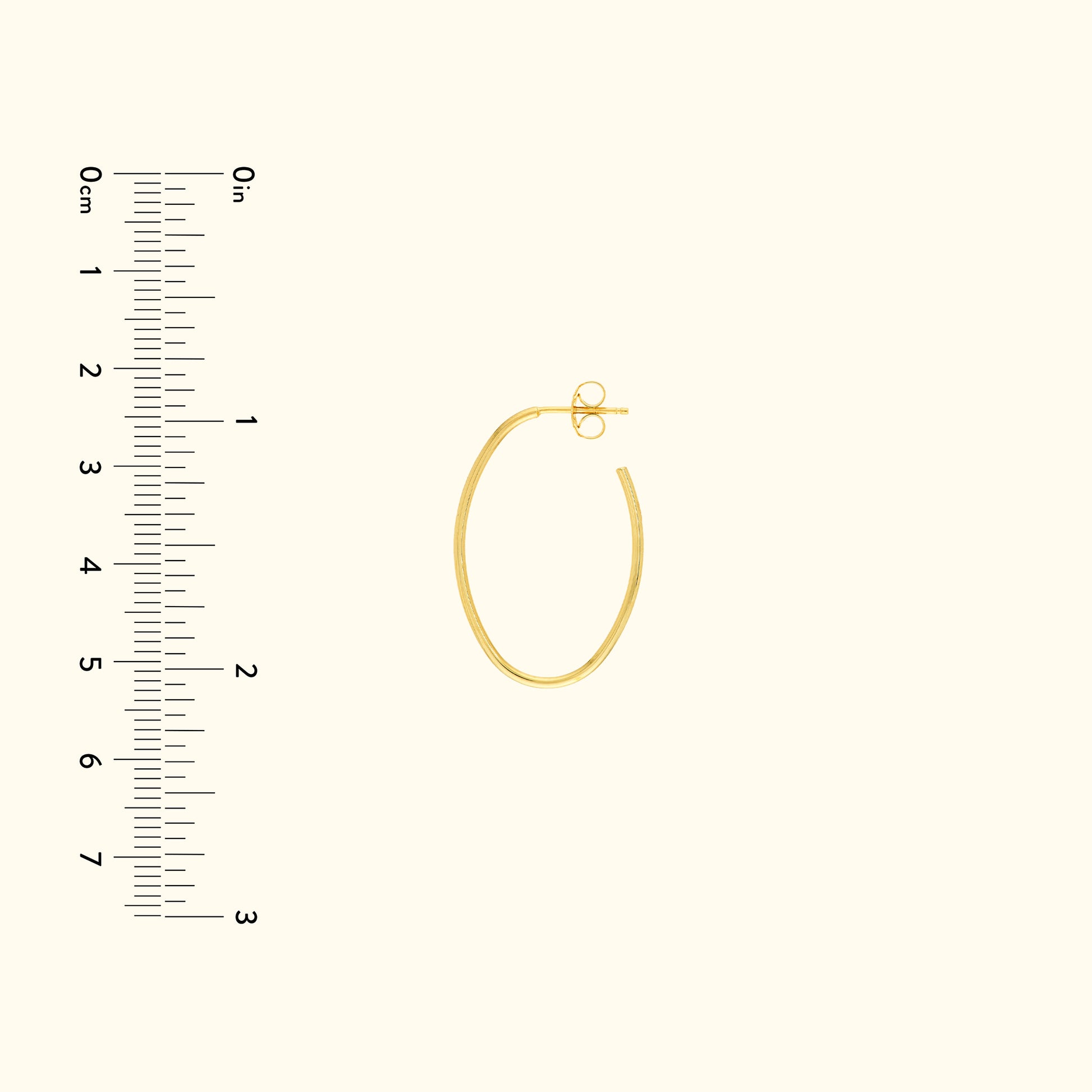 Gold hoop earring with a secure clasp, next to a ruler for size reference.