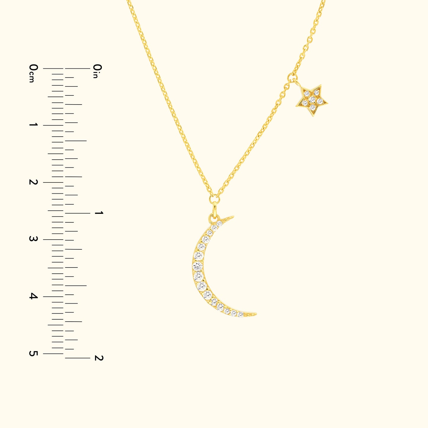 Gold necklace featuring a crescent moon and star, adorned with sparkling gems.