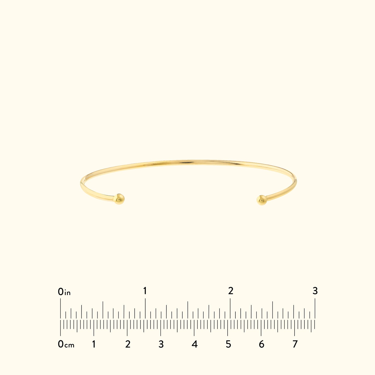 Simple gold cuff bracelet with rounded ends, set against a neutral background.