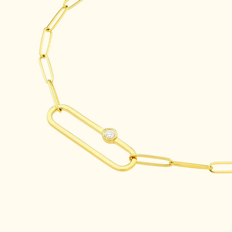 Gold chain necklace featuring elongated links and a central diamond accent.