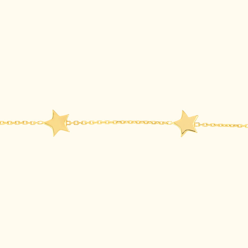 Delicate yellow gold bracelet featuring star-shaped charms.
