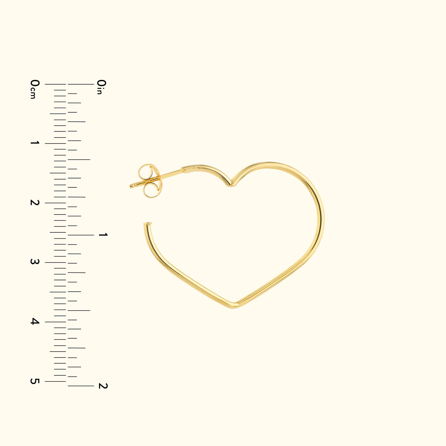 Gold heart-shaped hoop earring with a simple clasp, displayed alongside a ruler for size.