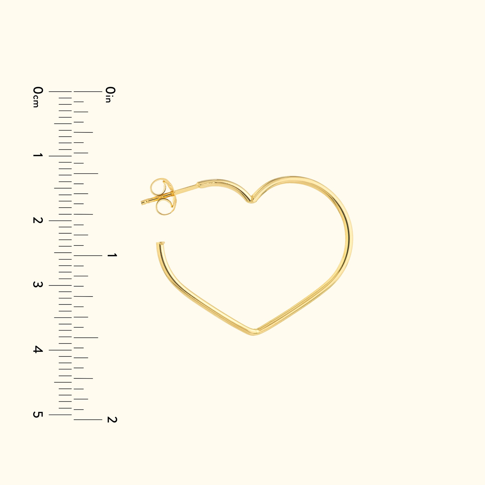 Gold heart-shaped hoop earring with a simple clasp, displayed alongside a ruler for size.