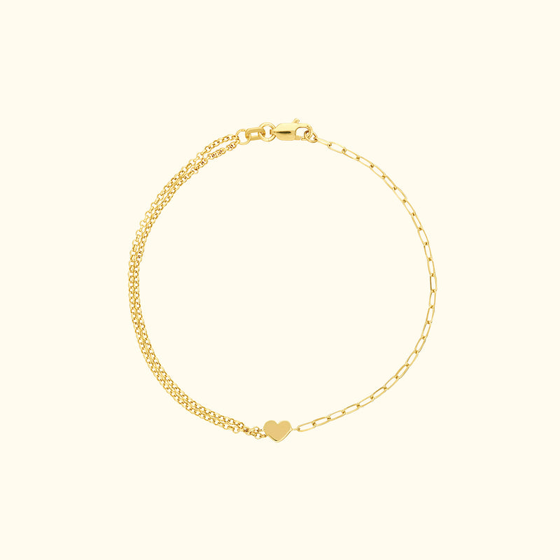 Delicate gold bracelet featuring a small heart charm.