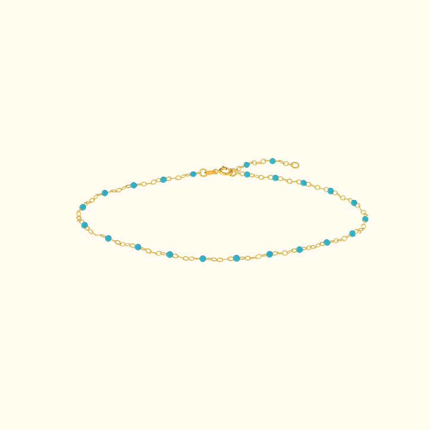 Gold chain bracelet adorned with small turquoise beads.