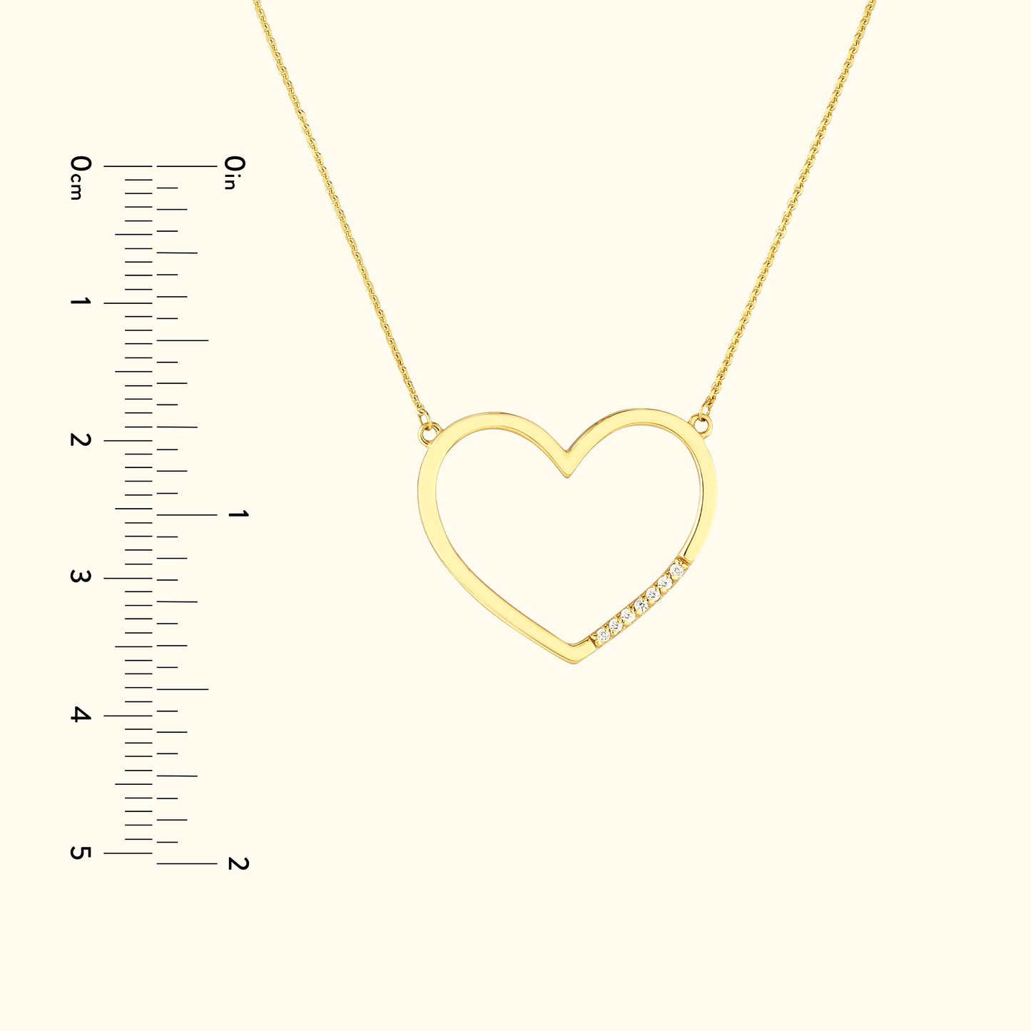 Gold heart-shaped necklace with small diamonds, positioned against a beige background.