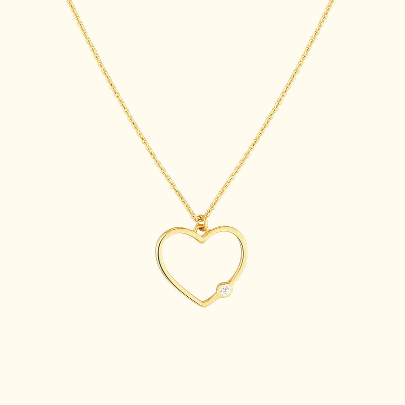 Gold heart pendant necklace with a small diamond accent.