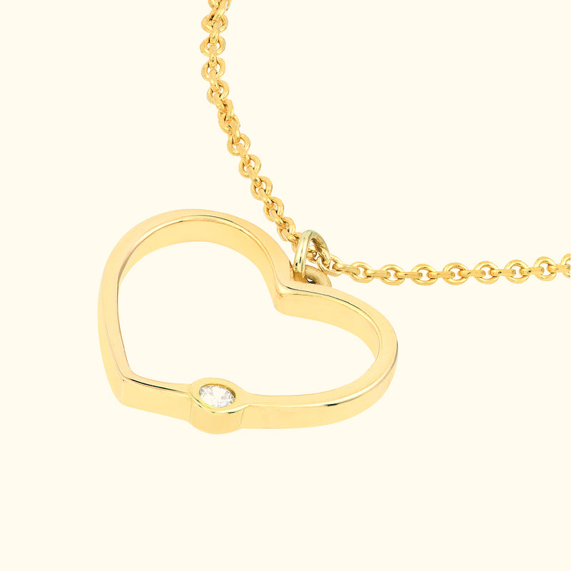 Gold heart-shaped necklace with a single diamond accent.