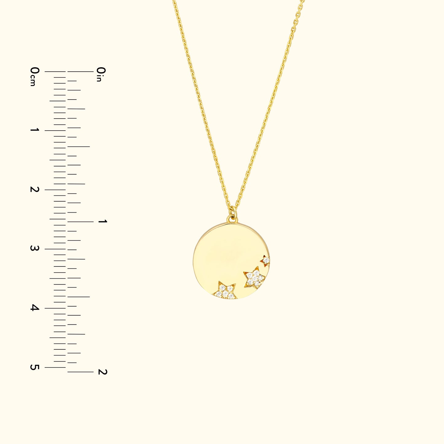 Gold pendant necklace with stars and diamonds, shown with a ruler for size reference.