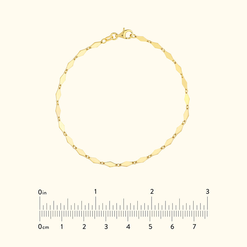 Delicate gold chain bracelet with hexagonal links and a clasp. Measurement scale included.