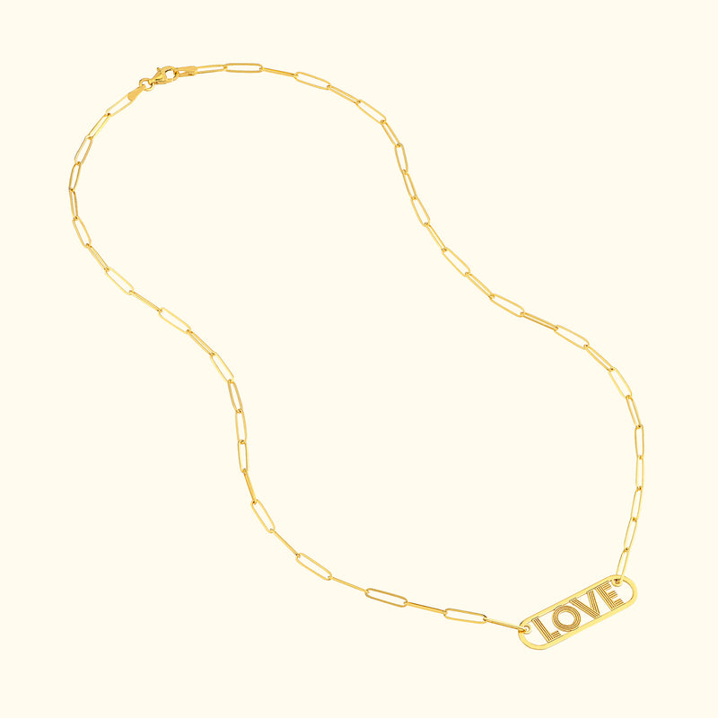 Gold necklace featuring the word "LOVE" in a pendant, linked with elongated chain.