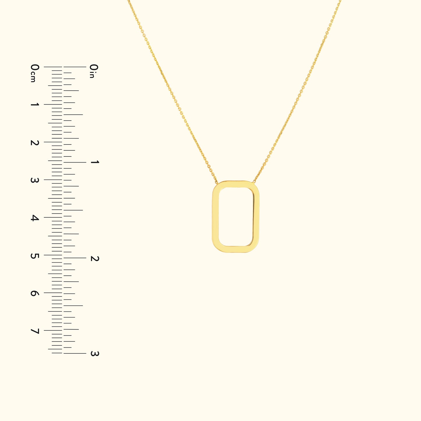 Gold rectangular pendant necklace on a delicate chain, displayed with a ruler for size reference.