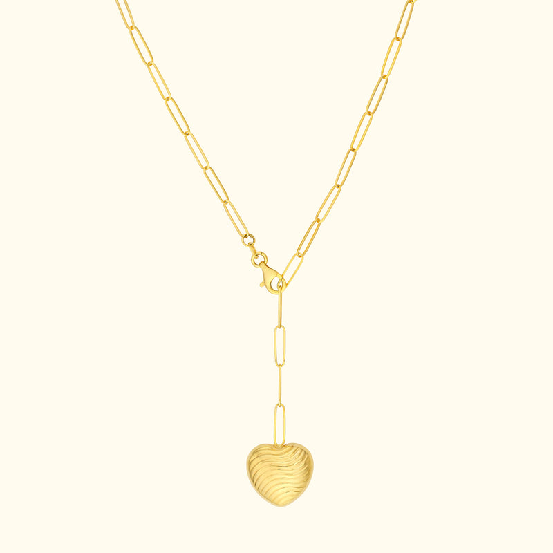 Gold heart pendant necklace on a delicate chain with elongated links.