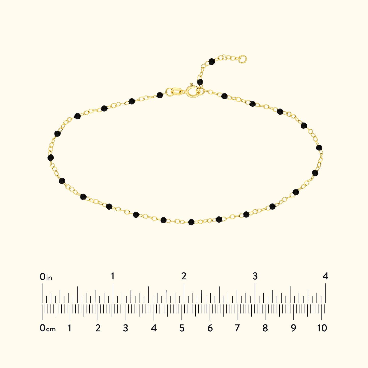 Gold bracelet with black beads, featuring a clasp and measuring scale below.
