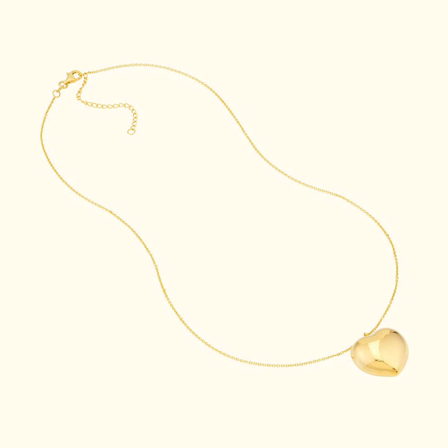 Gold necklace with a shiny heart-shaped pendant and a delicate chain.