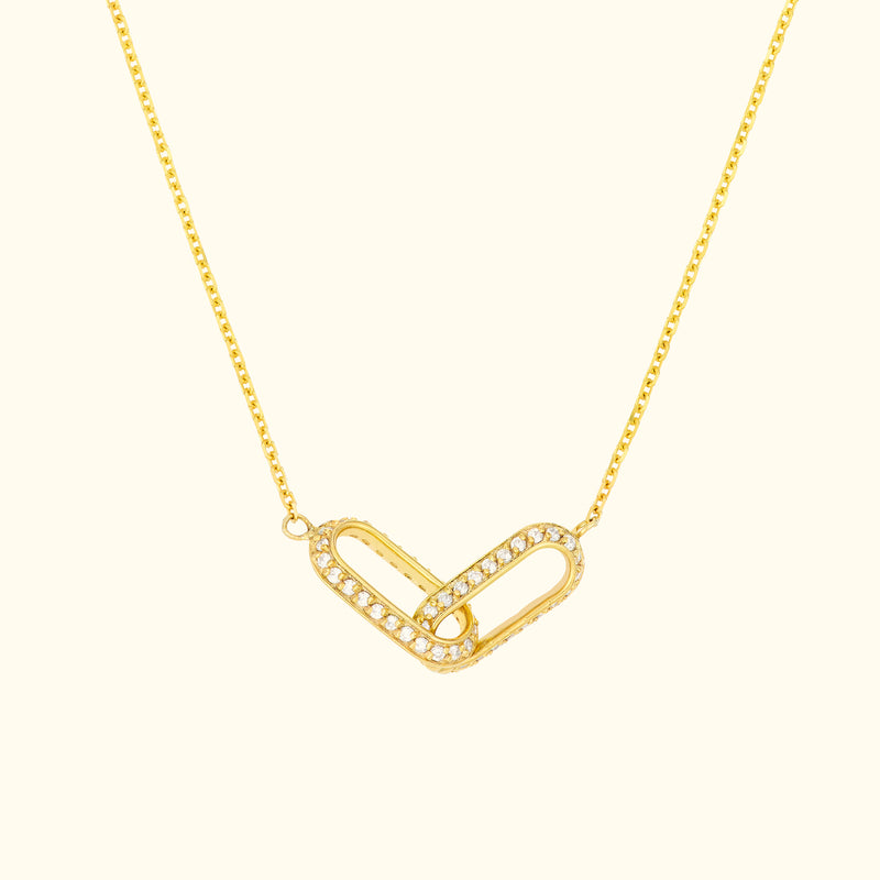 Gold necklace with a heart-shaped pendant adorned with sparkling diamonds.