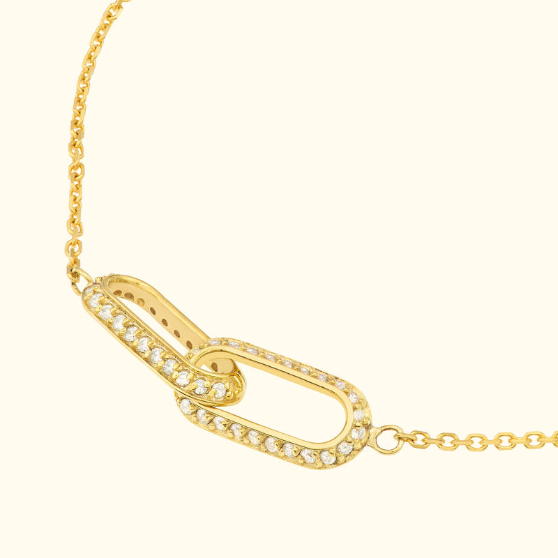 Gold chain necklace with a decorative, diamond-encrusted link.