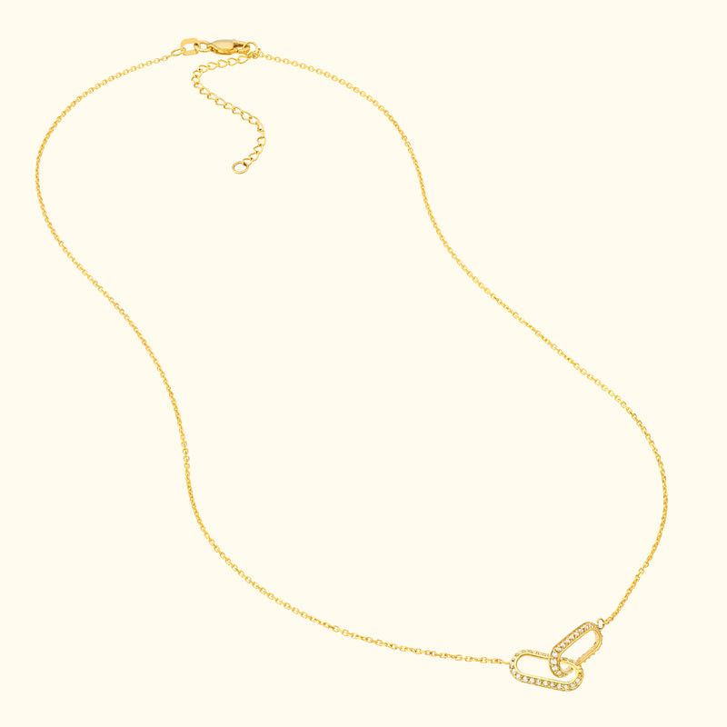 Delicate gold necklace featuring intertwined links with diamond accents.