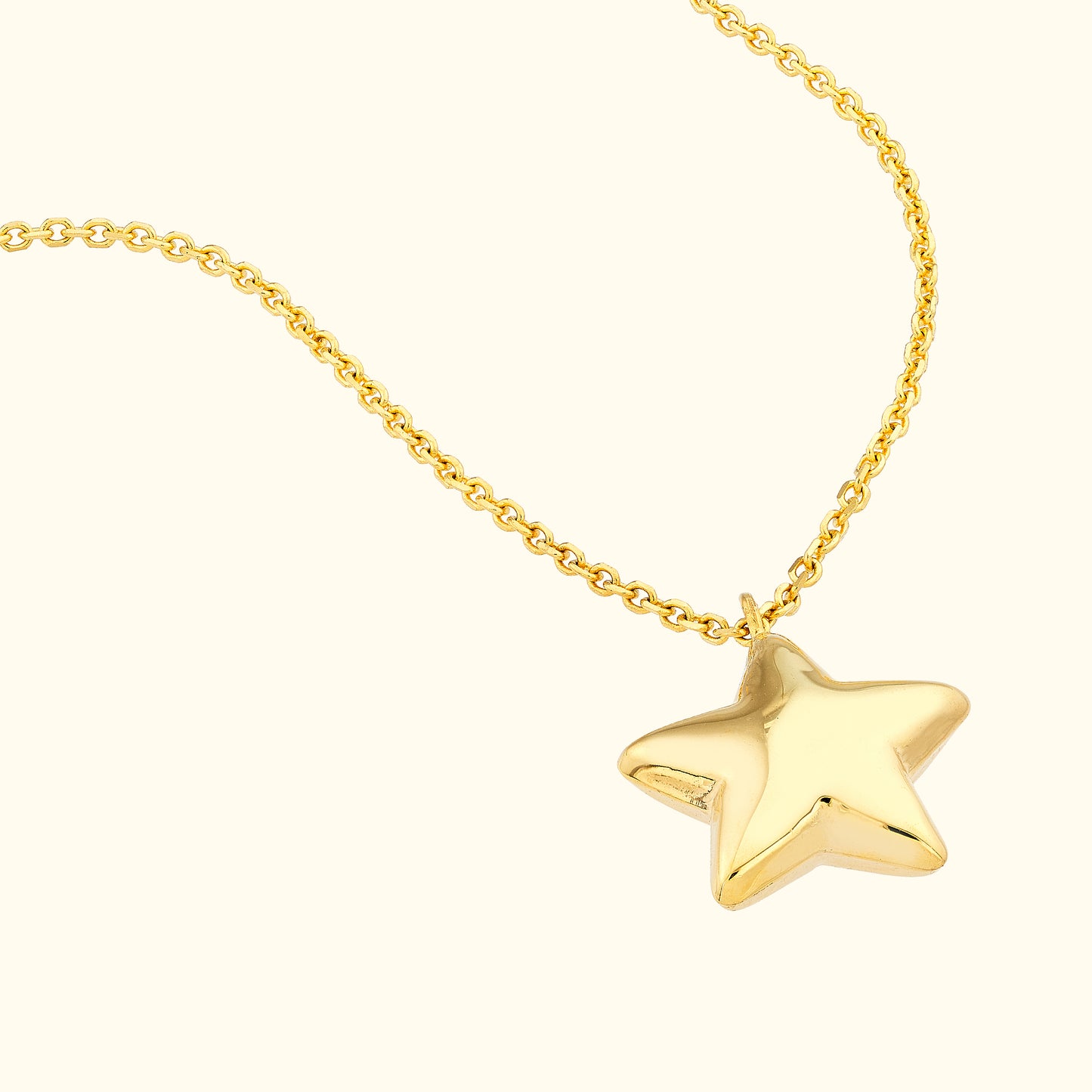 Gold star pendant necklace on a delicate chain.