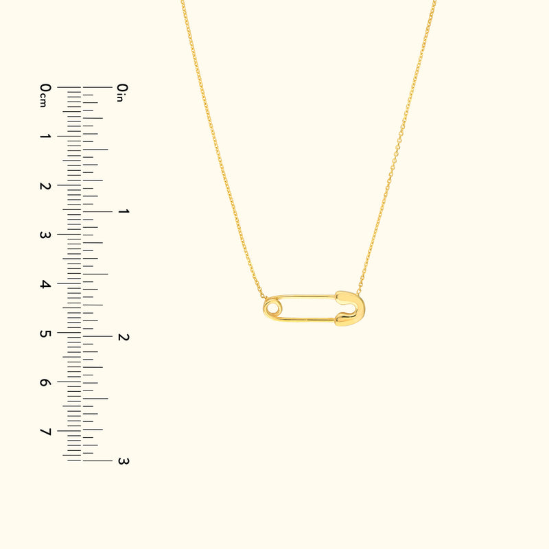 Gold safety pin necklace displayed next to a ruler for scale.