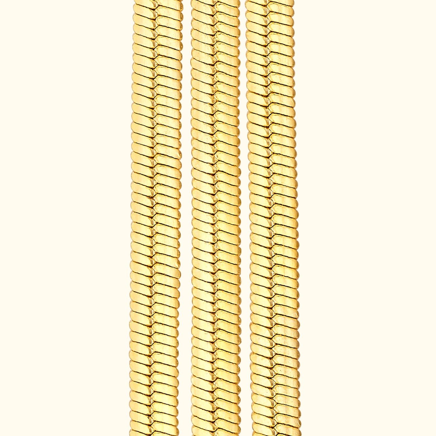 Three gold chains arranged vertically against a light background.