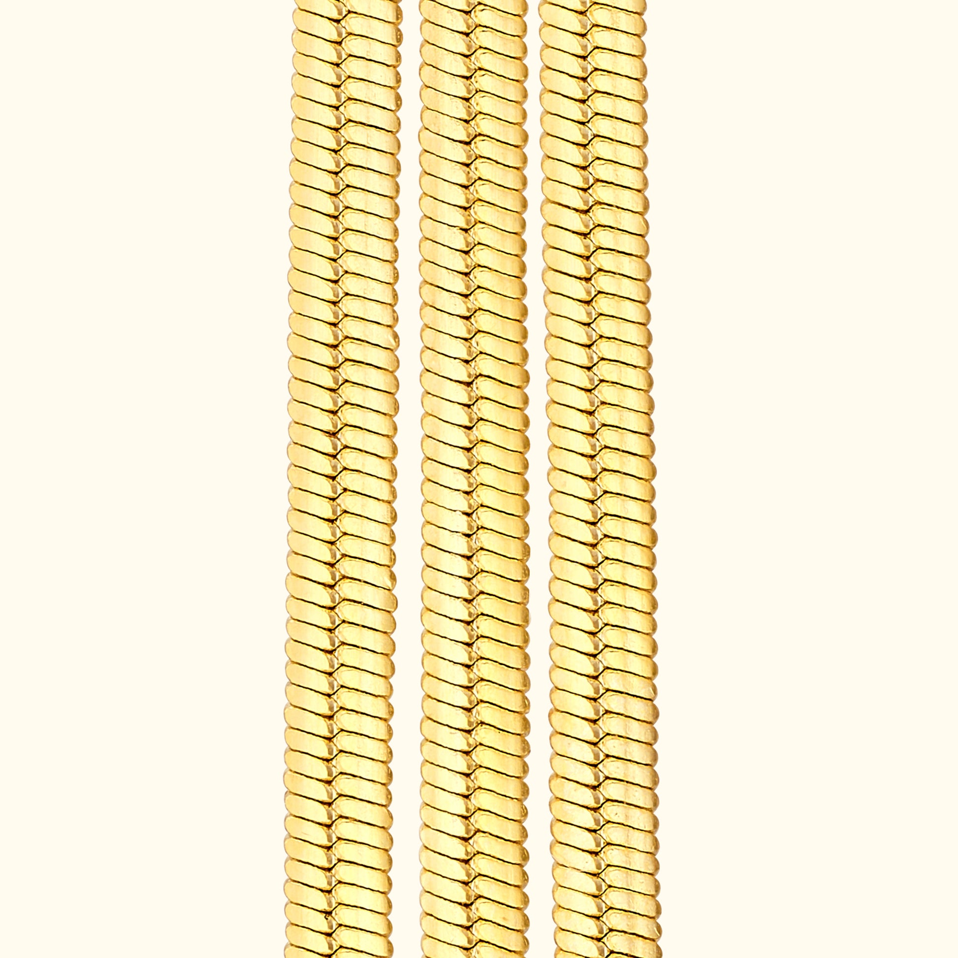 Three gold chains arranged vertically against a light background.
