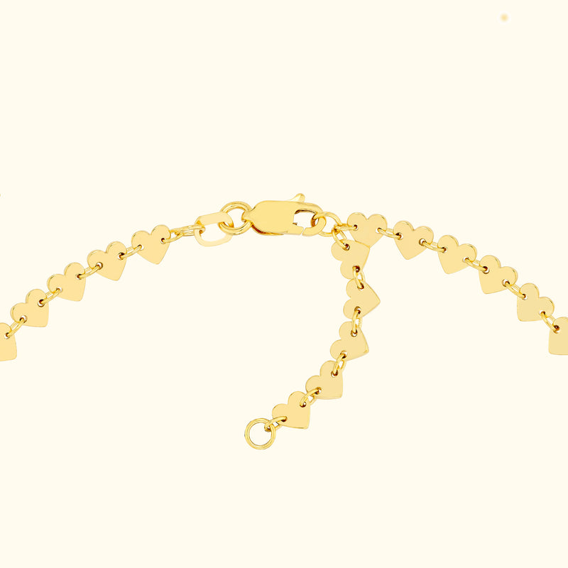 Gold heart-shaped charm bracelet with a secure clasp.