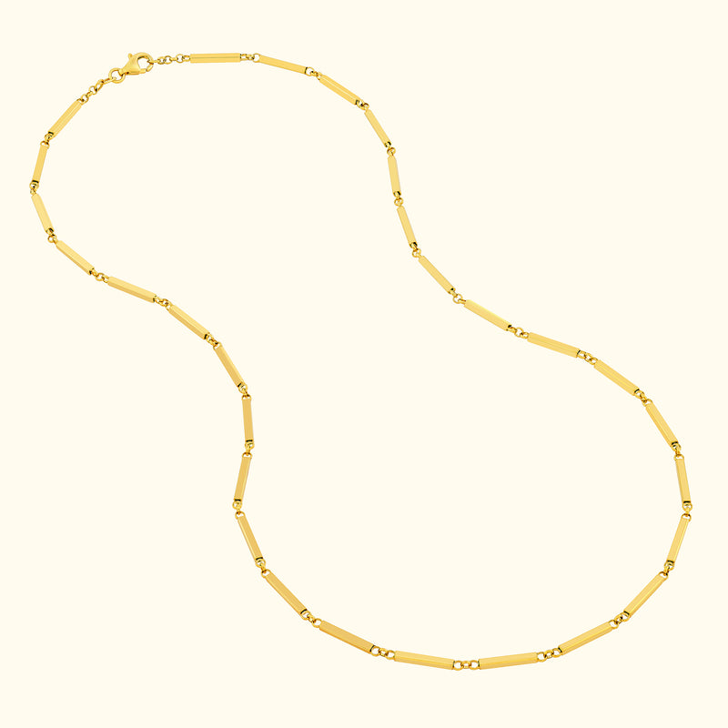 Gold chain necklace with rectangular links and decorative accents.