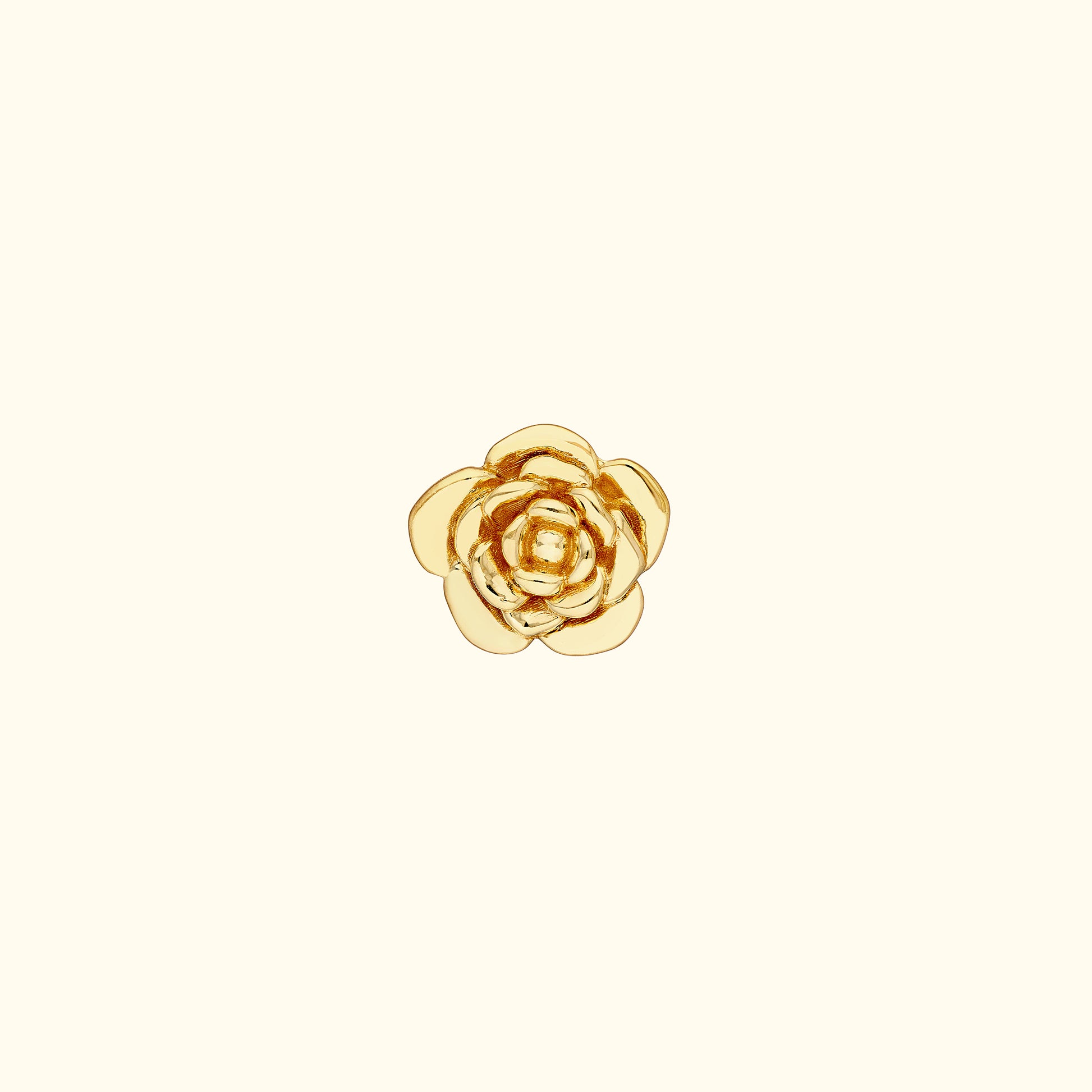 Gold flower-shaped ring with layered petals on a light background.