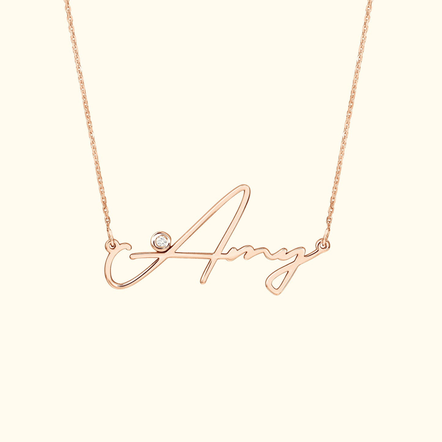 Rose gold necklace featuring a cursive name "Amy" with a small diamond accent.