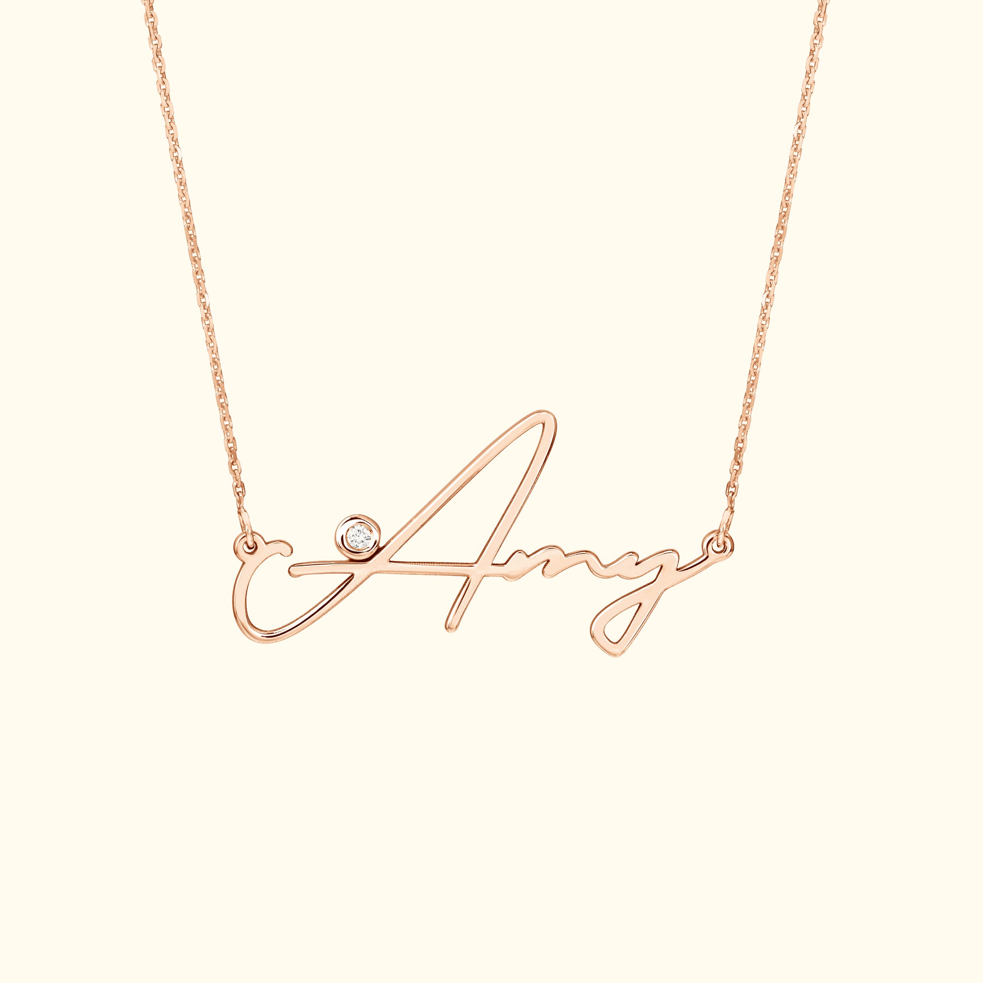 Rose gold necklace featuring a cursive name "Amy" with a small diamond accent.