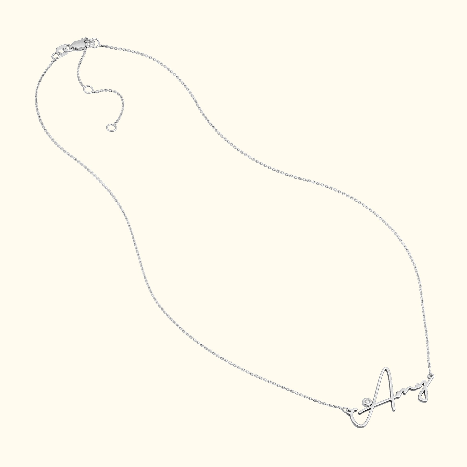 Silver necklace with a cursive letter "A" pendant.