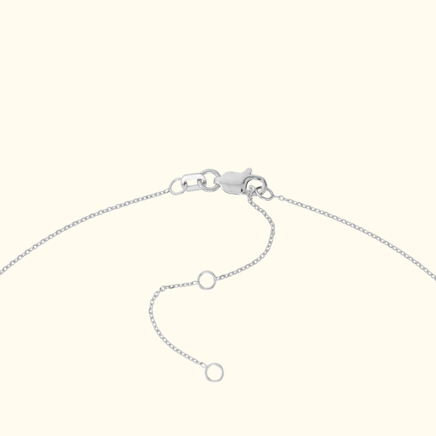 Silver bracelet clasp with adjustable chain links laid against a light background.