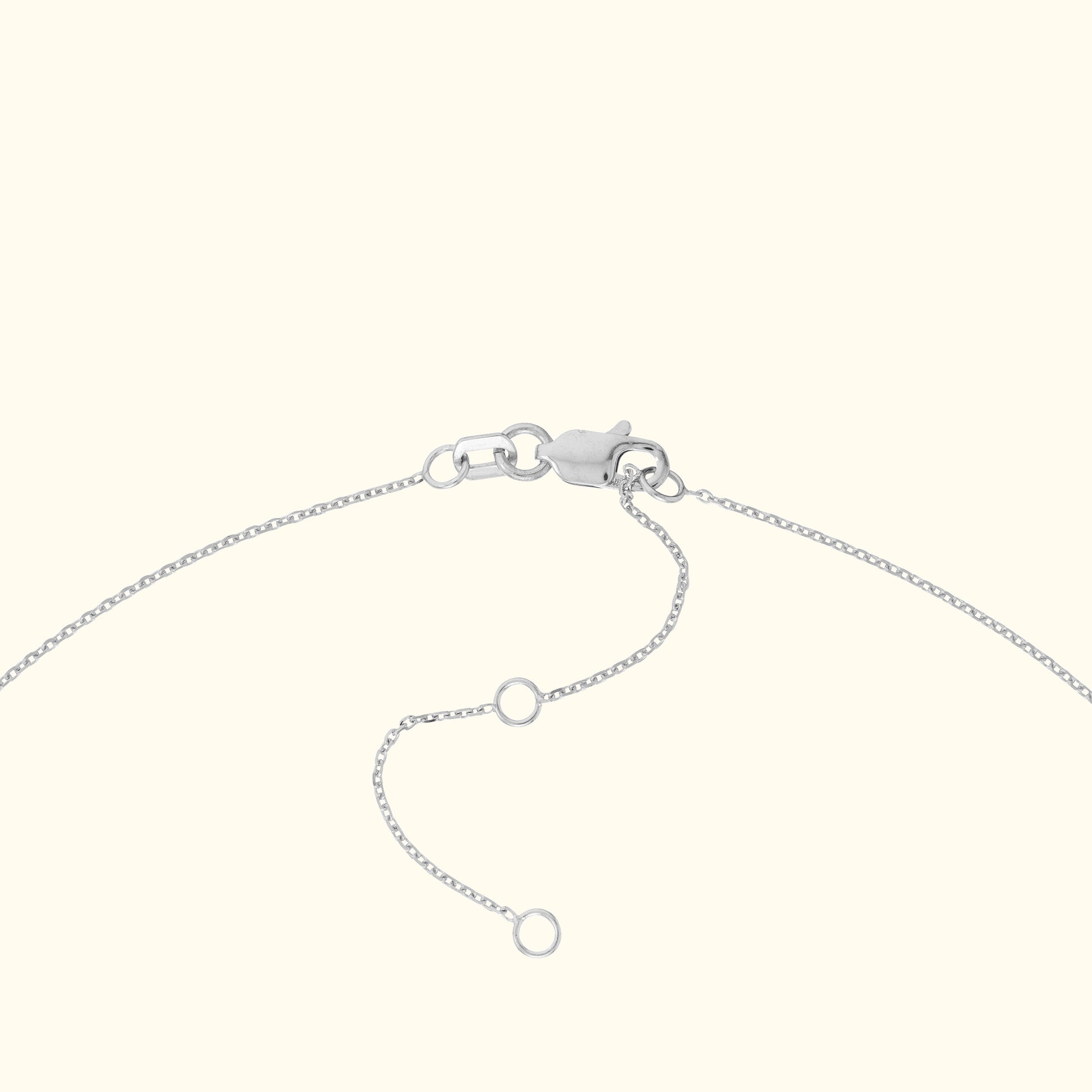 Silver bracelet clasp with adjustable chain links laid against a light background.