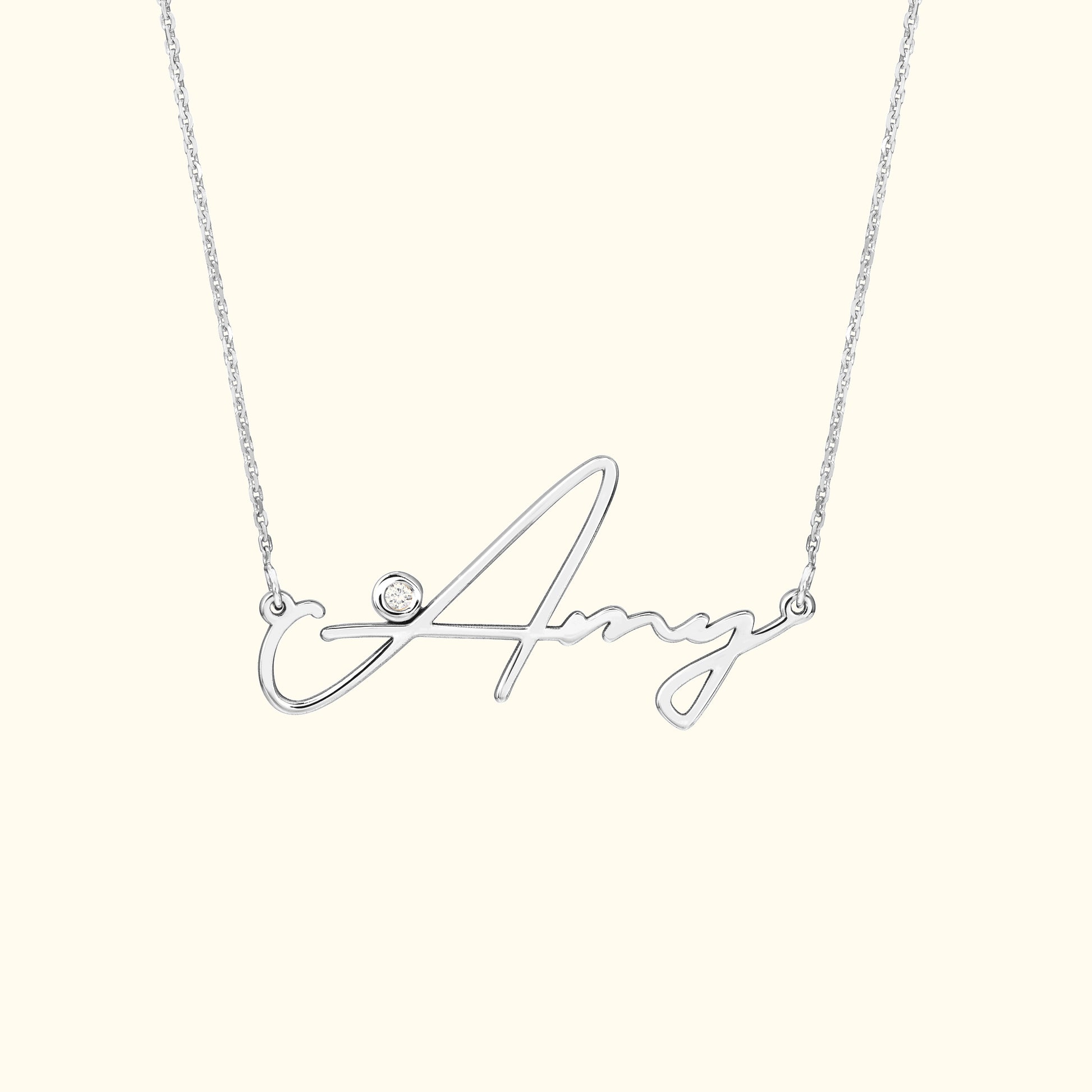 Silver necklace with a cursive name "Amy" and a small diamond accent.
