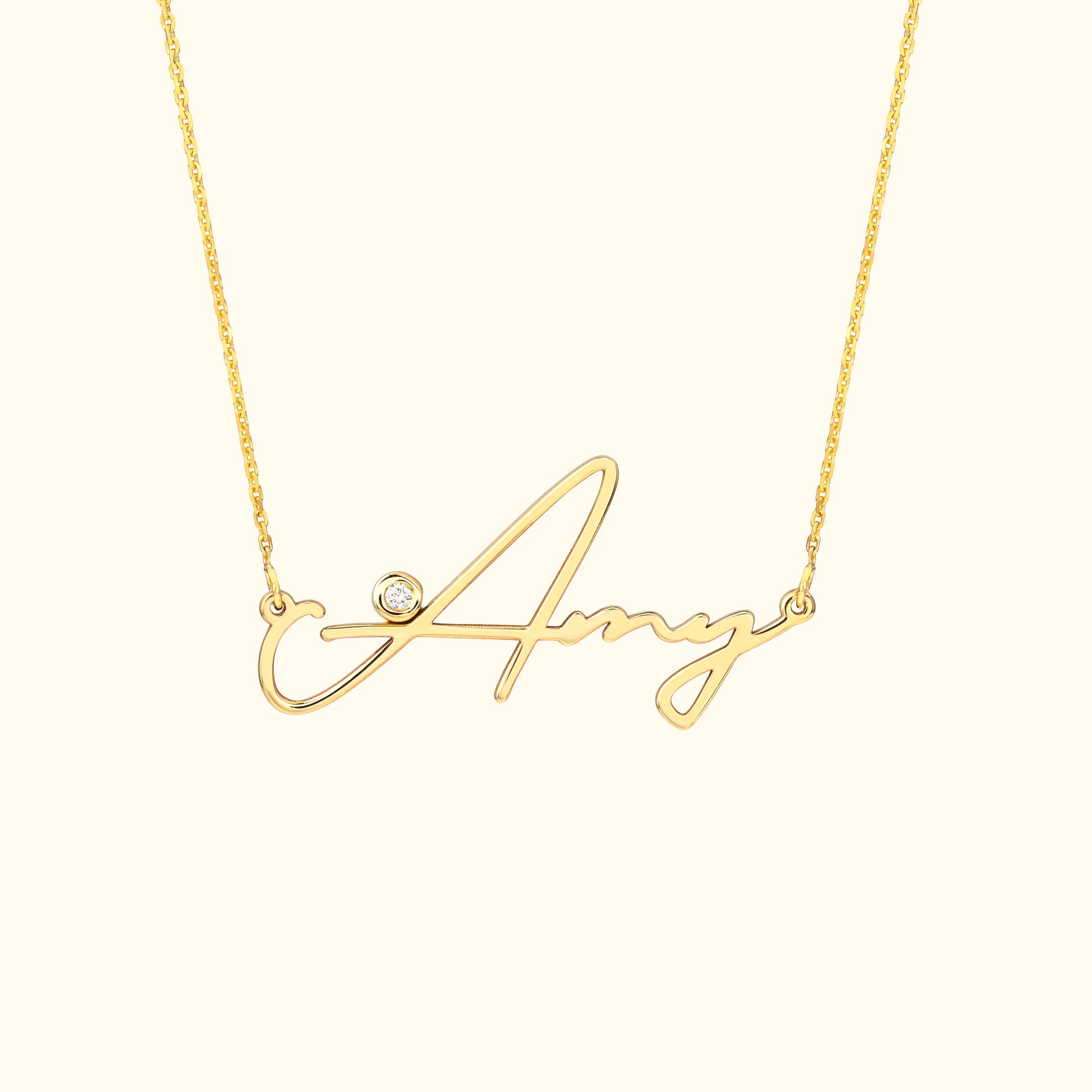 Gold necklace featuring a cursive name "Amy" with a small diamond accent.