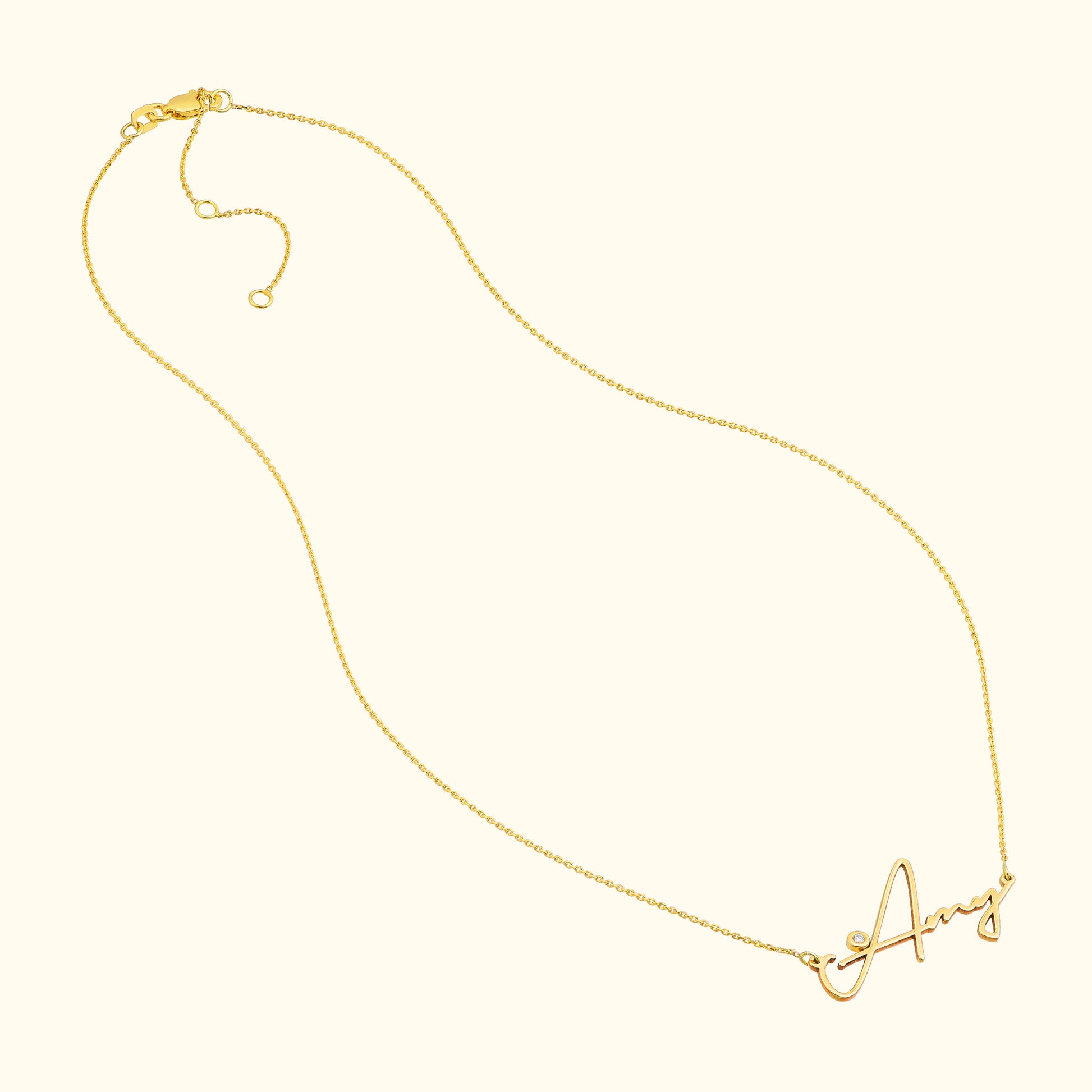 Gold necklace with a cursive letter "A" pendant.