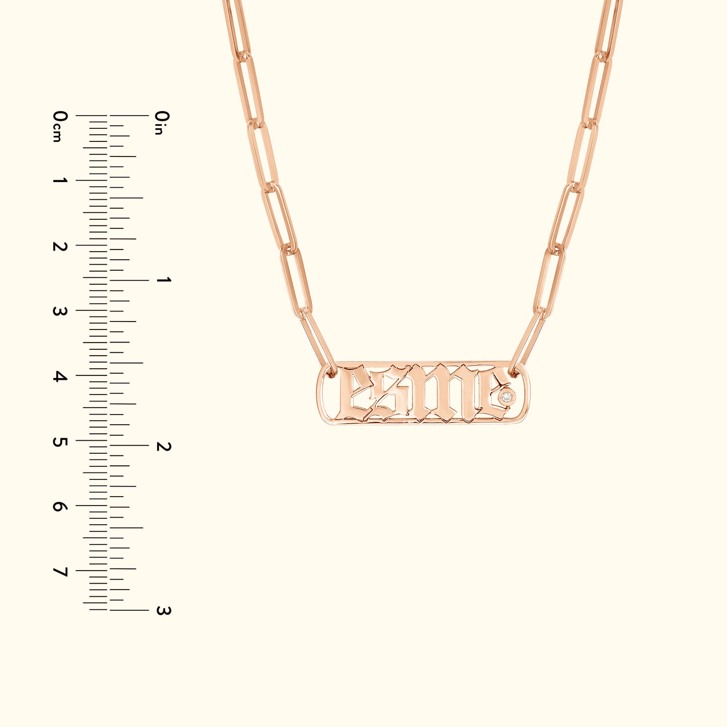Rose gold chain necklace with a rectangular nameplate and decorative font.