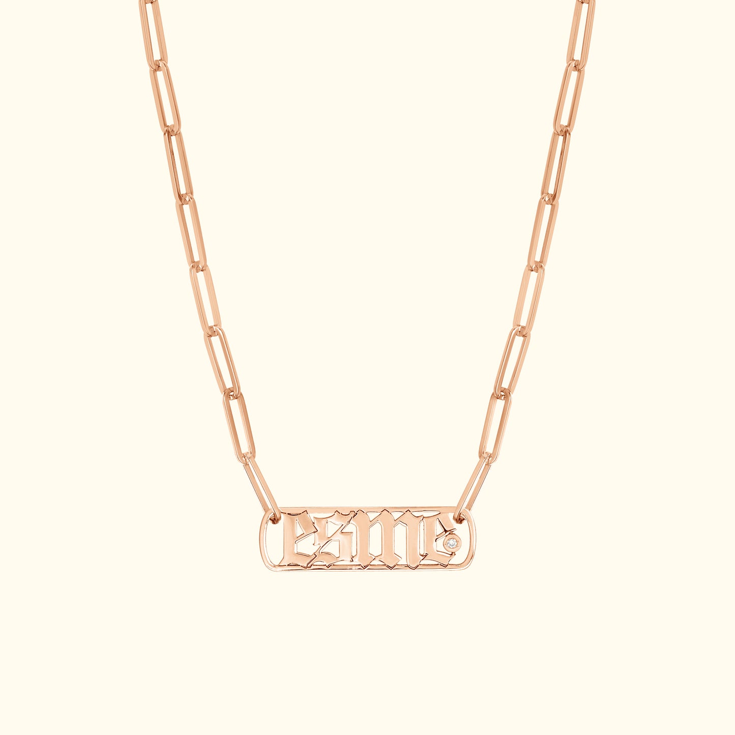Rose gold chain necklace with a rectangular pendant featuring engraved lettering and a diamond accent.