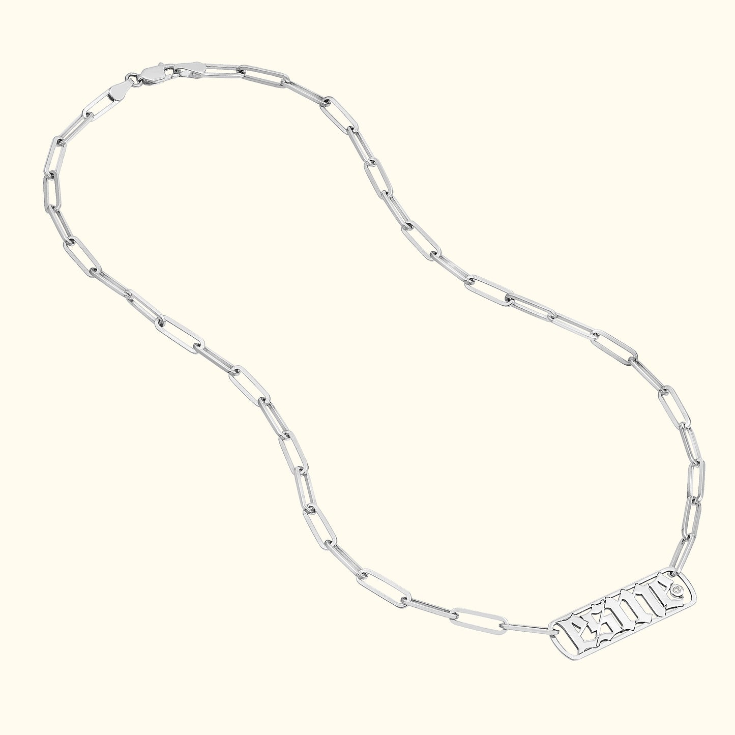 Silver chain necklace with rectangular tag pendant.