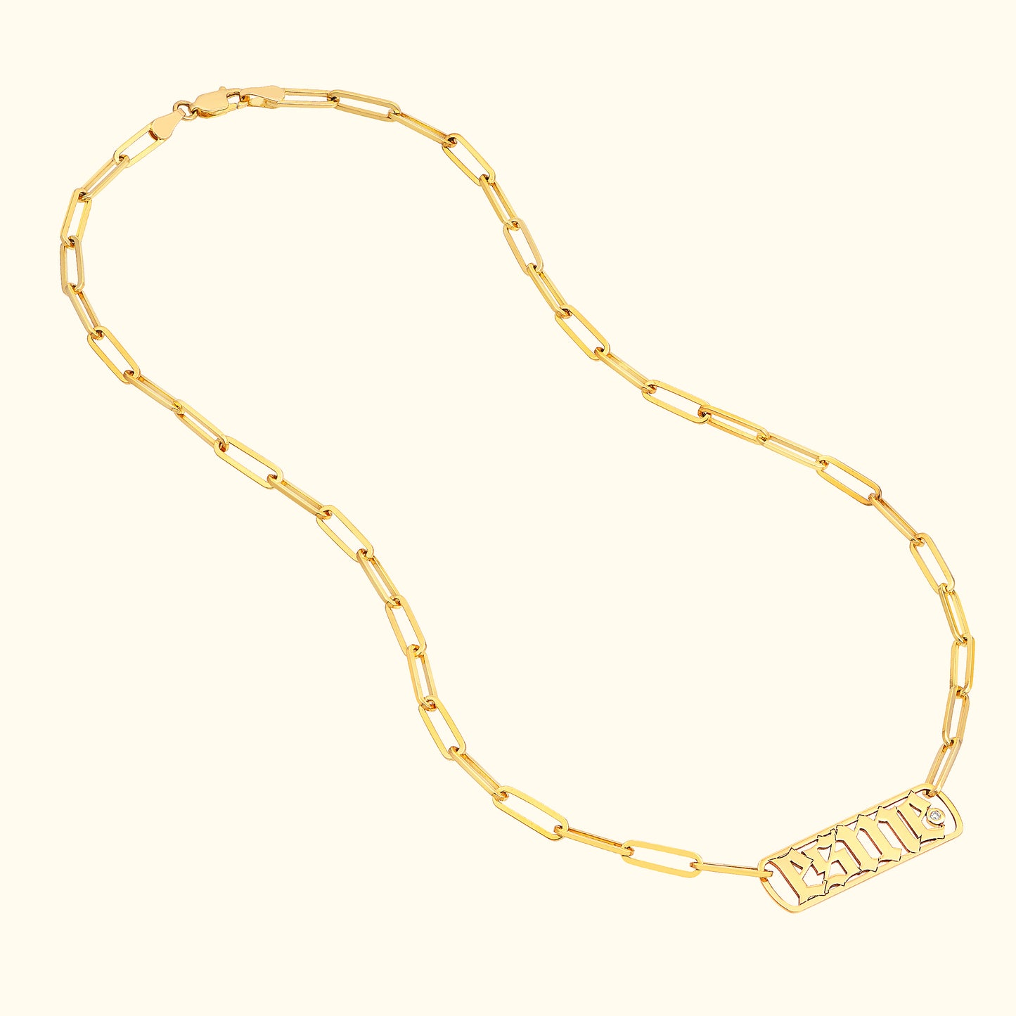 Gold chain necklace with rectangular links and an engraved pendant.