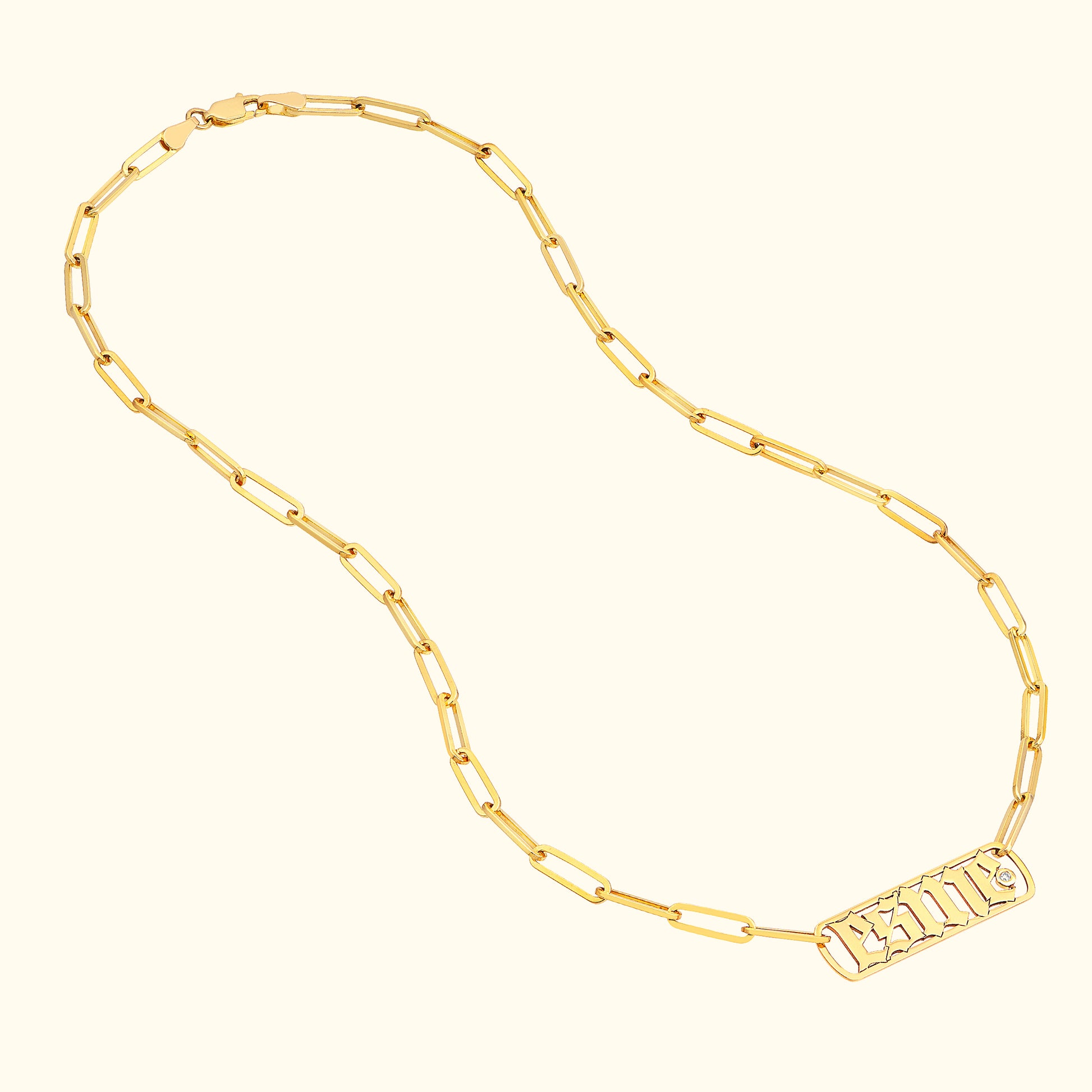 Gold chain necklace with rectangular links and an engraved pendant.