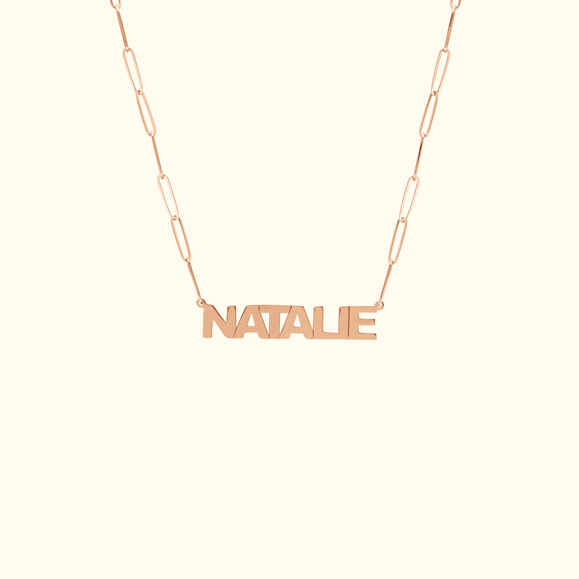 Rose gold name necklace with the word "NATALIE" on a delicate chain.