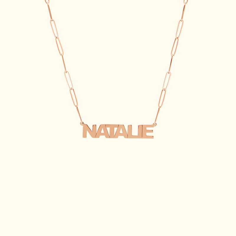 Rose gold name necklace with the word "NATALIE" on a delicate chain.