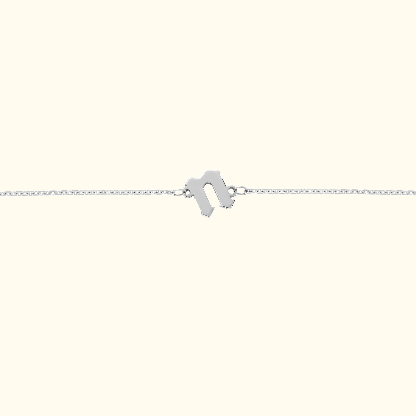 Minimalist silver bracelet featuring a geometric clasp on a light background.