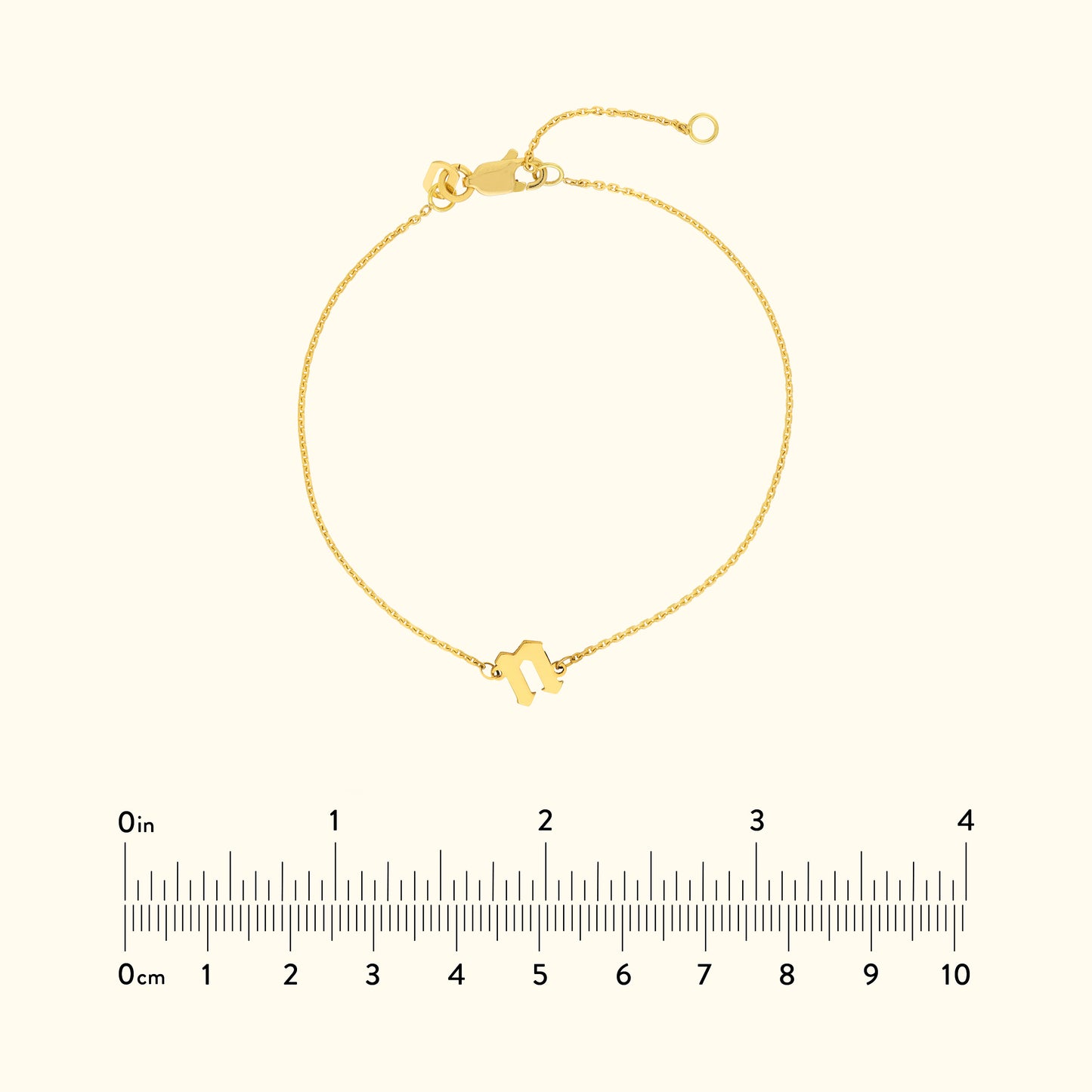 Golden bracelet with a minimalist design and a clasp, displayed with a ruler for scale.